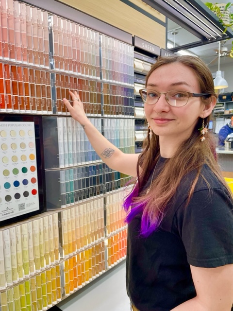 Katelynn pointing knowingly at a wall of paint swatches